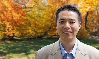 Ming-Te Wang, a smiling Taiwanese man with short brown hair wearing a tan suit and blue button up shirt.